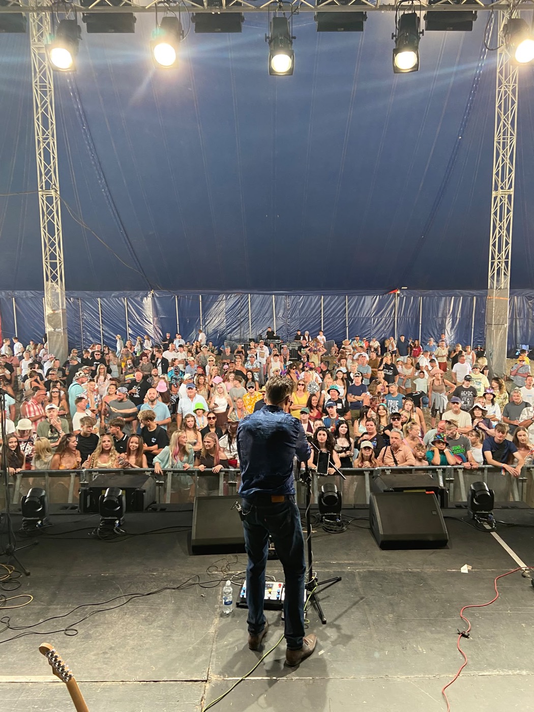 The Artificial Monkeys on stage at Poole Harbour Festival facing a packed tent of thousands